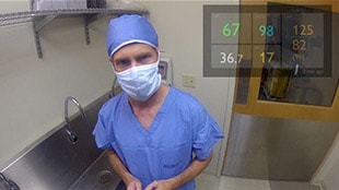 Doctor in OR with vital signs in top right corner of view.