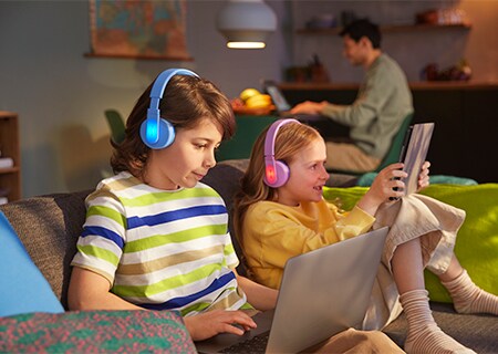 Lapset käyttämässä Philipsin korvan päälle asetettavien kuulokkeiden värikästä valopaneelitoimintoa