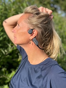 Nainen, joka käyttää Philipsin luujohtumiseen perustuvia Bluetooth-kuulokkeita