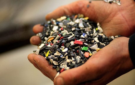 Lähikuva käsistä, jotka pitelevät rikkinäisiä materiaalinpaloja.